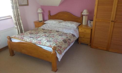 a bedroom with a wooden bed and a dresser with a bed sidx sidx sidx at Ethan House B&B in Rosscarbery