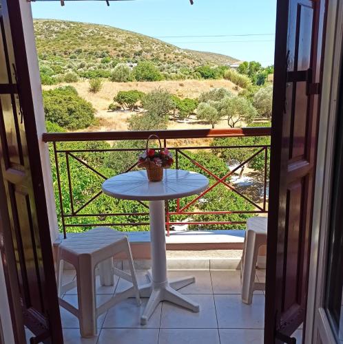 a table and chairs on a balcony with a view at ChiosRoomsMaria in Armólia