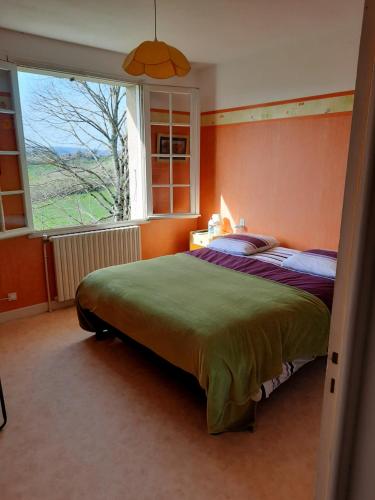 a bedroom with a bed and a large window at Maison et jardin dans le Lot! Chambres chez l'habitant! in Belmont-Bretenoux