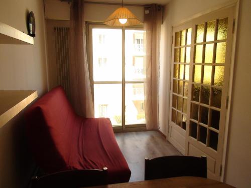 - un salon avec un canapé rouge et une fenêtre dans l'établissement Grand Studio Hyères Piscine Jardins du Luxembourg 2ème étage, à Hyères