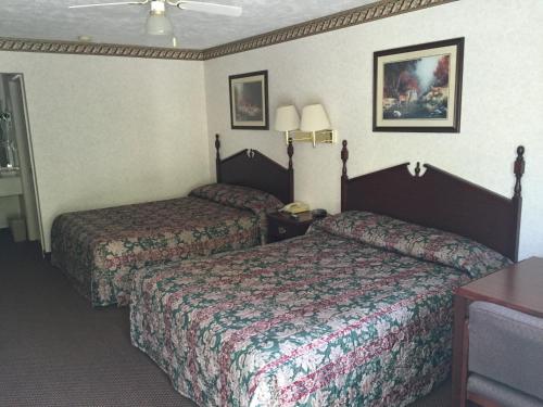 a hotel room with two beds and a table at Deerfield Inn in Somerville