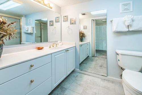 a bathroom with a toilet and a sink and a mirror at Shoreline Towers 3074 in Destin