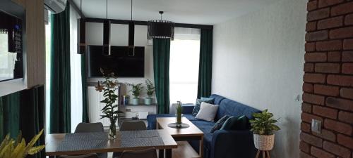 a living room with a blue couch and a table at Apartament Bernata-Śródka in Poznań