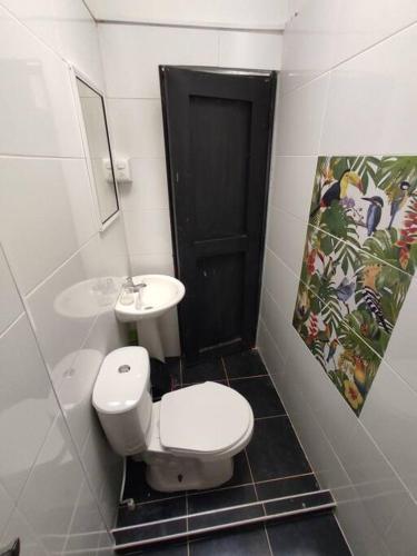 a bathroom with a white toilet and a sink at Cucú Ardilla Vivienda Campestre en Pance in Cali