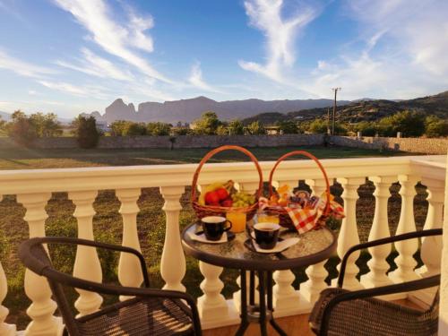 a table with a basket of fruit on a balcony at Spilaio at Meteora in Kalabaka
