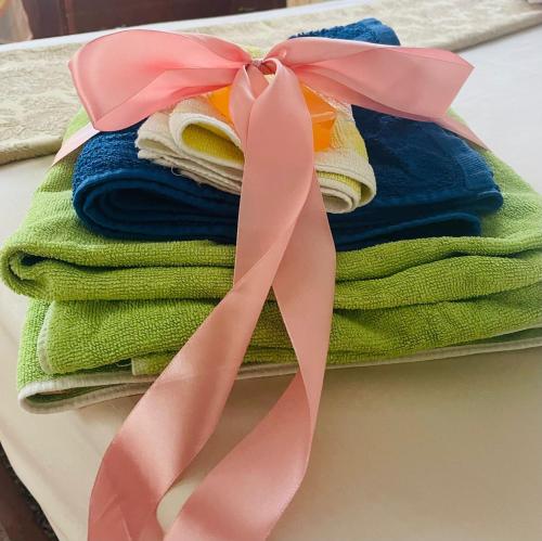 um monte de toalhas com uma fita rosa sobre uma mesa em La Casa Dei Ricordi em Lanciano