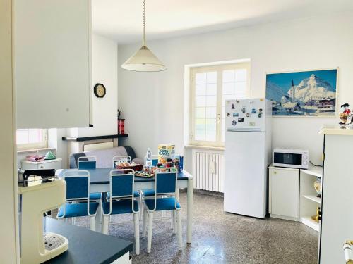 cocina con mesa, sillas y nevera en La Casa Dei Ricordi, en Lanciano