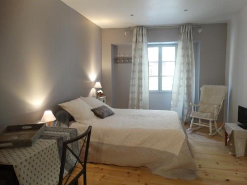 une chambre avec un grand lit et une fenêtre dans l'établissement Chambres d'hôtes indépendantes au rez-de-chaussée d'une maison provençale dont une avec cour intérieure, à Tarascon