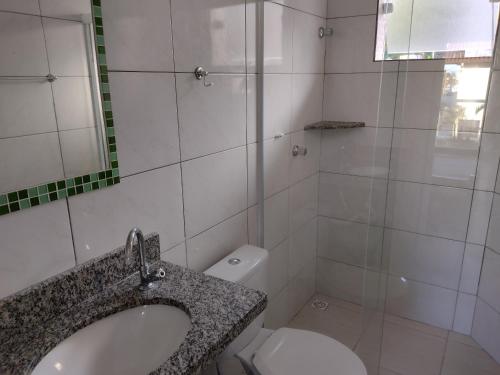 a bathroom with a sink and a toilet at Apartamentos Margarida in Ubatuba