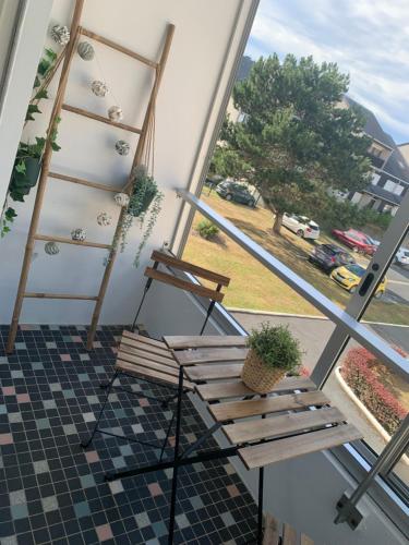 a bench on a balcony with a view of a street at L'escale in Courseulles-sur-Mer