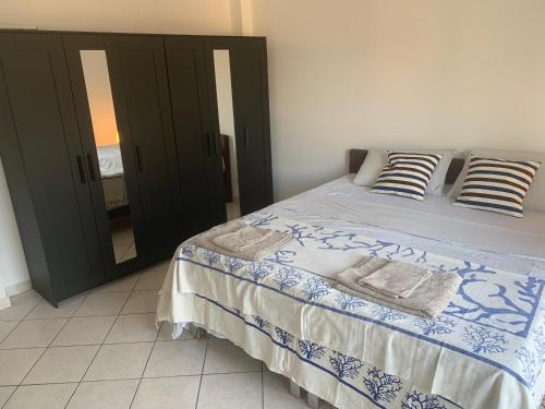- une chambre avec un lit doté de draps bleus et blancs et d'un miroir dans l'établissement Tavernola recidence, à Côme