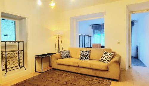 uma sala de estar com um sofá e um candeeiro em Casa Giulia em Luino