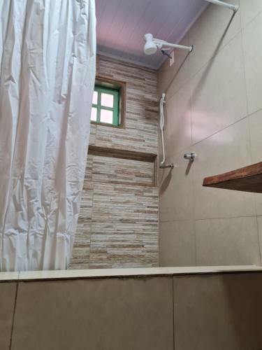 y baño con ducha y cortina de ducha. en Suítes Pirenópolis, en Pirenópolis