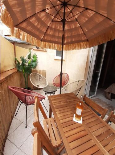 stół i krzesła pod parasolem na tarasie w obiekcie Bordeaux Chartrons superbe T2 avec terrasse w mieście Bordeaux