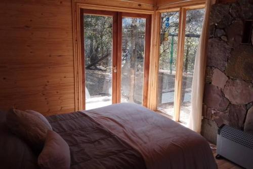 1 dormitorio con 1 cama frente a una ventana en El silencio - Lozano- Jujuy en San Salvador de Jujuy
