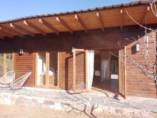 a wooden cabin with a porch and a chair on a patio at El silencio - Lozano- Jujuy in San Salvador de Jujuy