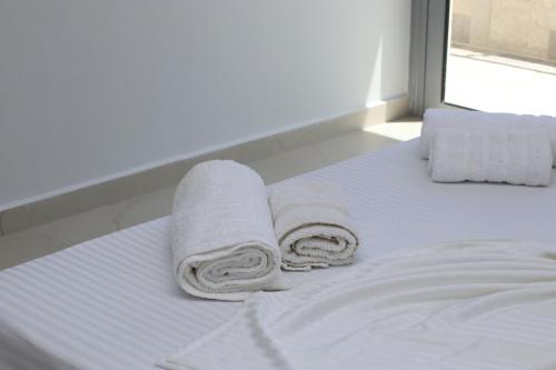 a white bed with towels on top of it at Vourtaréa Guesthouse in Himare