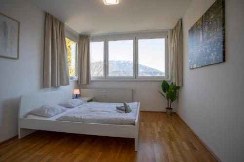 インスブルックにあるTop of Innsbruck Apartment I free parkingのベッドルーム1室(ベッド1台、窓2つ付)