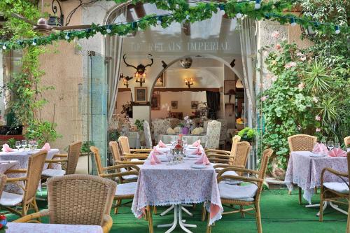 un restaurant avec des tables et des chaises et des serviettes roses dans l'établissement Logis Le Relais Imperial, à Saint-Vallier-de-Thiey