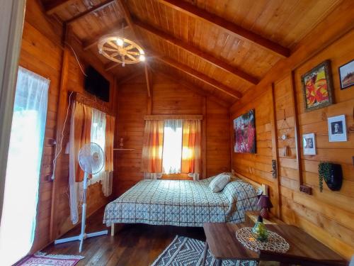 ein Schlafzimmer mit einem Bett in einer Holzhütte in der Unterkunft Casa La Agapia in Agapia