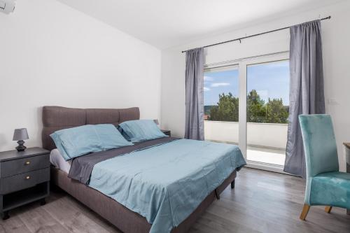 a bedroom with a bed and a large window at Vila Sole in Rtina