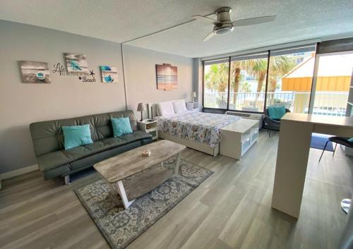 ein großes Wohnzimmer mit einem Bett und einem Sofa in der Unterkunft Castaways Resort Studios in Daytona Beach