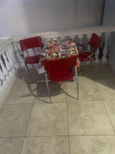 a table with red chairs and a table with food on it at Eriola apartament in Orikum