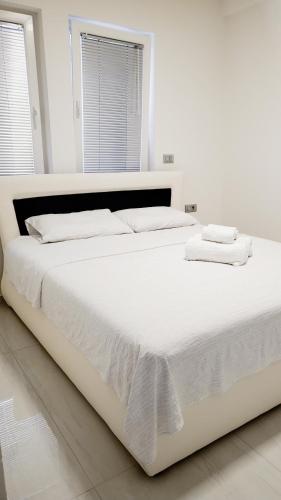 a white bed with white sheets and towels on it at Villa Koki in Ohrid