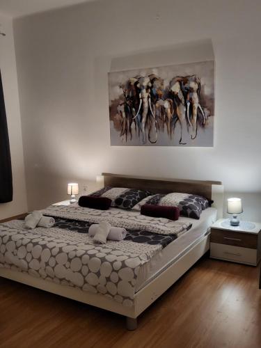 a bedroom with a bed with a painting on the wall at Rijeka apartment with free parking and large balcony in Rijeka
