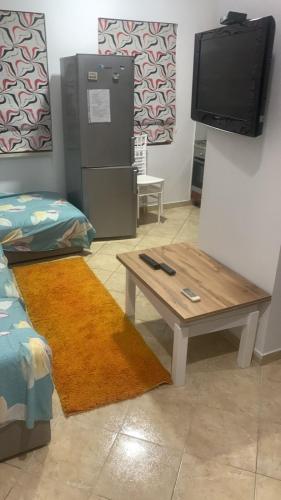 a living room with a table and a tv at Eriola apartament in Orikum