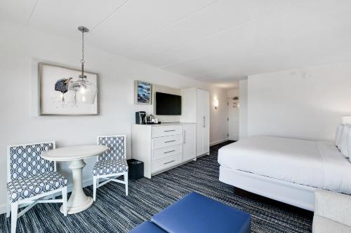 a bedroom with a bed and a table and chairs at ICONA Windrift in Avalon