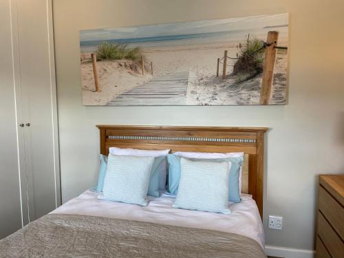 a bedroom with a bed with a picture of a beach at the mod pod studio in Mtunzini