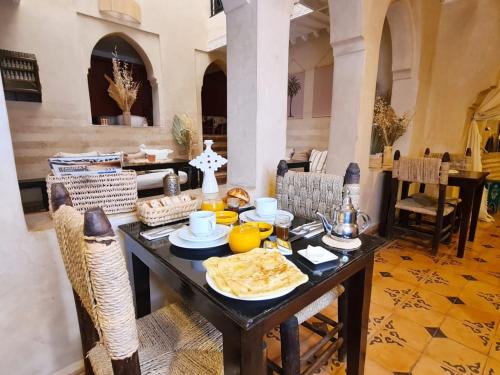 uma sala de jantar com uma mesa com comida em Riad Casa Sophia em Marraquexe