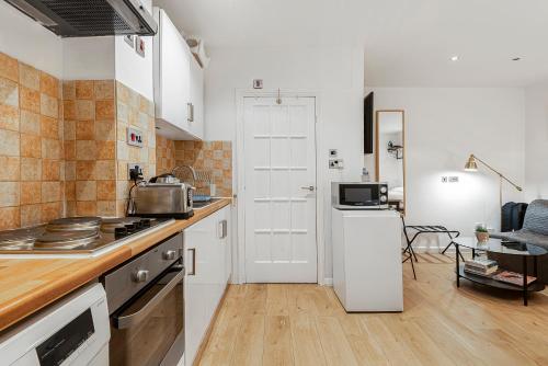 ロンドンにあるBeautiful Hyde Park Studio Flatのキッチン(コンロ、白い冷蔵庫付)