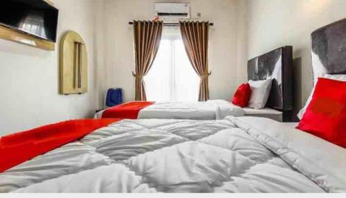 sypialnia z 2 łóżkami i oknem w obiekcie THE TISPA SYARIAH RESIDENCE w mieście Palembang