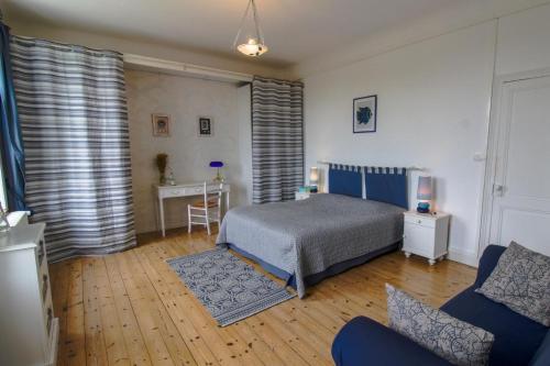- une chambre avec un lit, une table et un canapé dans l'établissement Le Logis du Canal, à Marennes