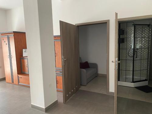 - une chambre avec une porte ouverte et un canapé dans l'établissement Apartamenty pod Wierzbami, à Dwikozy