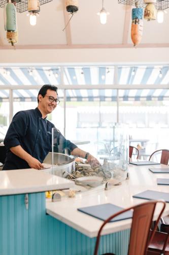 a man standing in a kitchen preparing food at The Tides Inn in West Irvington