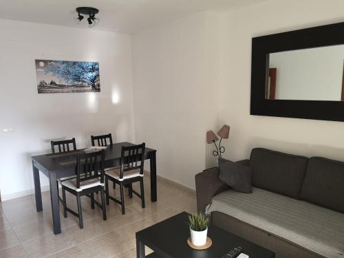 a living room with a couch and a table and chairs at Apartamento 60 m2 en la playa in Torre de Benagalbón