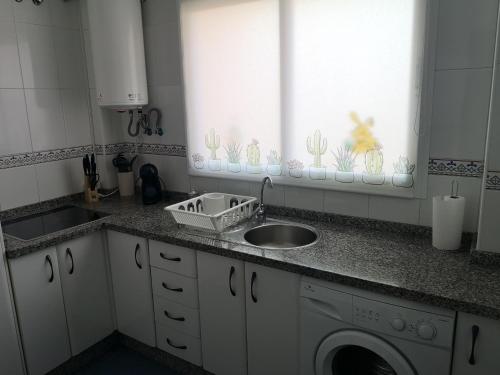 a kitchen with a sink and a washing machine at Apartamento 60 m2 en la playa in Torre de Benagalbón