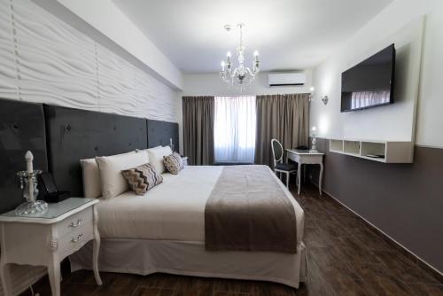 a bedroom with a bed and a desk and a television at Ker San Telmo Hotel in Buenos Aires