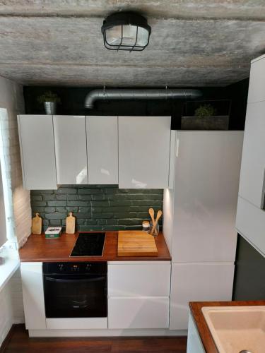 a kitchen with white cabinets and a black stove at Loksapark1 in Loksa