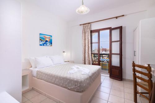 a bedroom with a bed and a balcony at Mandilaria Studios in Perivolos