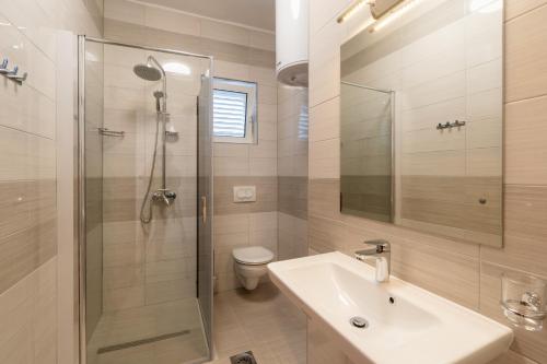 bagno con lavandino, doccia e servizi igienici di Apartments Blažević a Pirovac (Slosella)