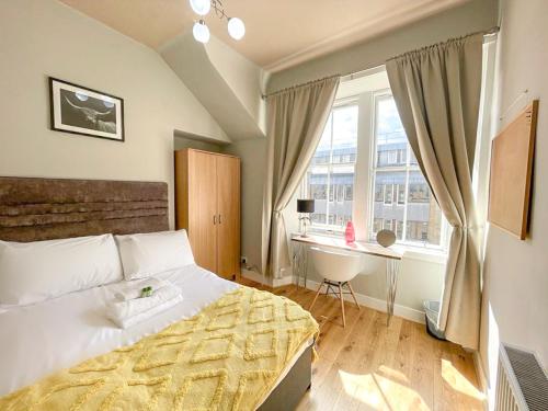 a bedroom with a bed and a desk and a window at Charming 3 Bed Apartment in Old Town in Edinburgh