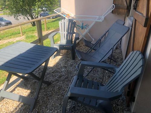 two chairs and a table and a bench on a porch at SUPER BESSE Appartement LE GÎTE BESSARD 6 couchages Le Bois de la Reine in Besse-et-Saint-Anastaise
