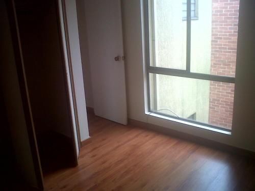 an empty room with a window and a wooden floor at Mirador del parque in Bogotá