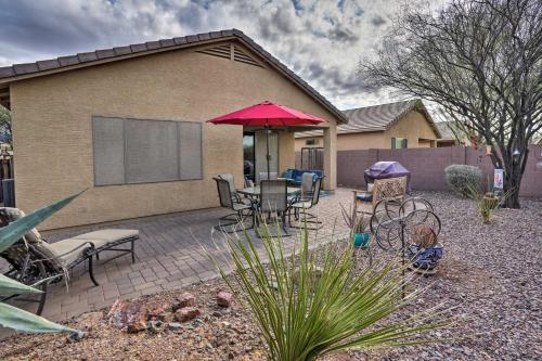 a patio with a table and chairs and an umbrella at Luxe Anthem Home with Grilling Patio Near Hiking! in Anthem