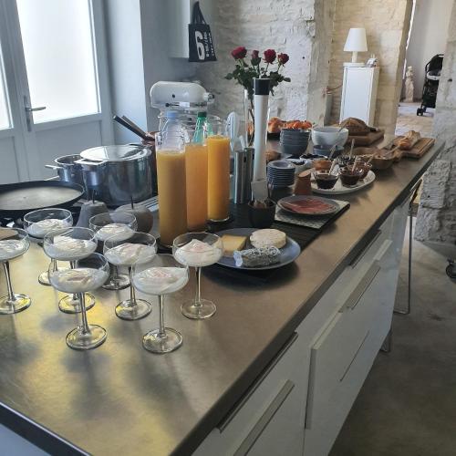 - un buffet de plats et de boissons sur un comptoir dans l'établissement Maison Laurenza 2 chambres d'hôtes, à Saint-Jean-de-Liversay