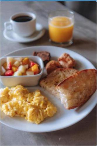 a plate of breakfast food with eggs toast and a cup of coffee at Socialtel Lapa Rio de Janeiro in Rio de Janeiro